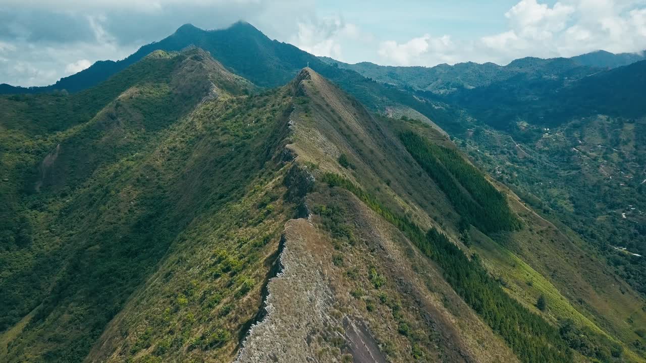 Drone flying forward along the sharp ridge of a mountain range deep in the Colombian highlands.