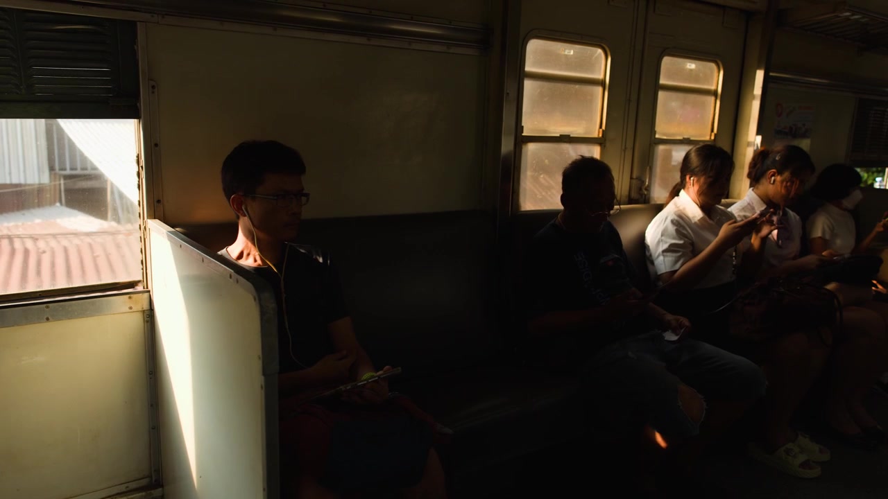 タイの都市の屋根を通り過ぎるレトロな列車内の乗客の車内風景