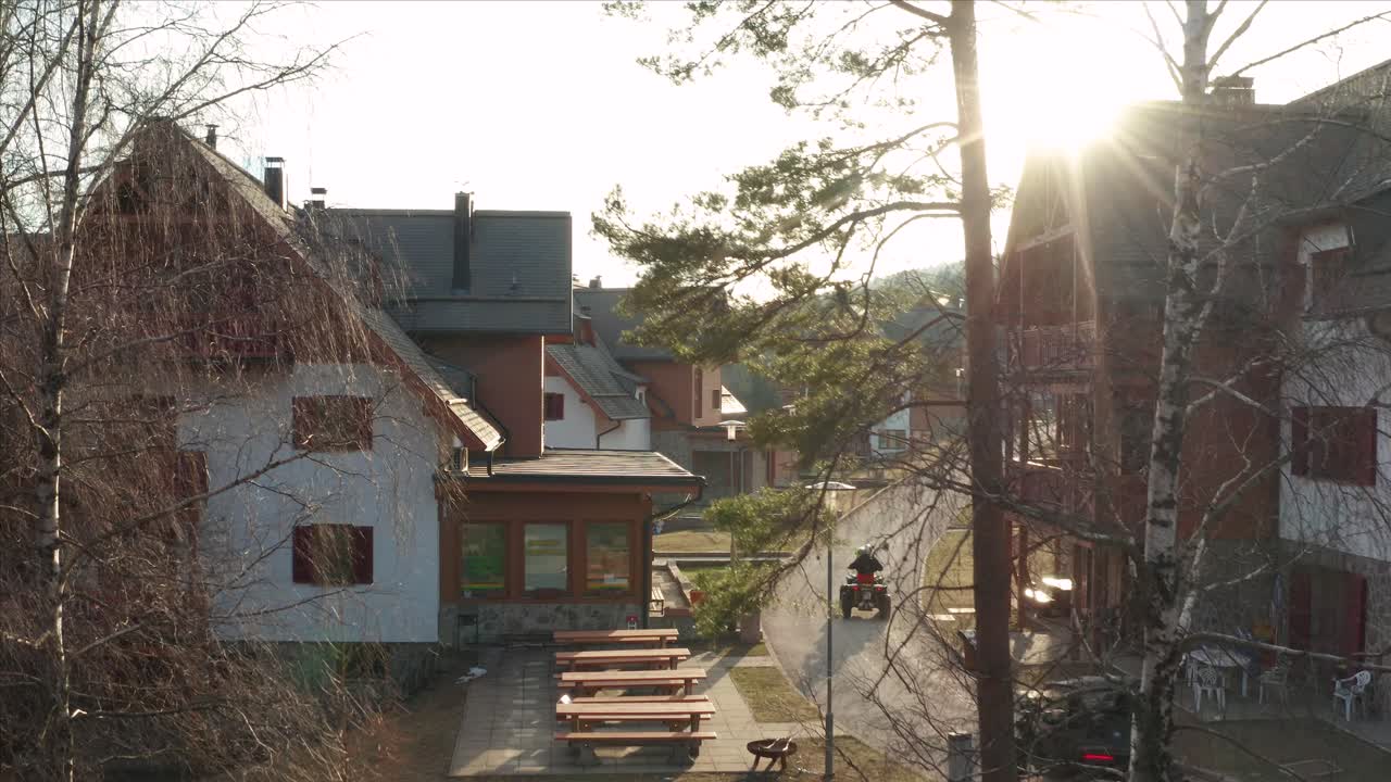 gente montando en quads viajando por la carretera de un pueblo rural durante el amanecer