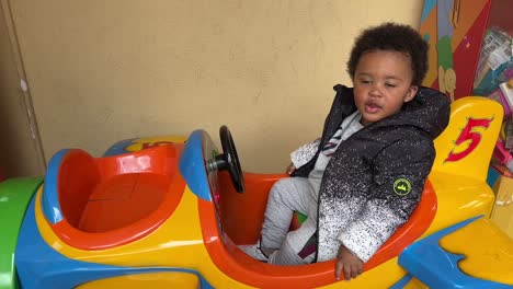 2-year-old-afroeuropean-baby-enjoying-in-a-toy-plane