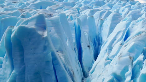grandes grietas que se derriten en el glaciar azul iluminado por el sol, de cerca