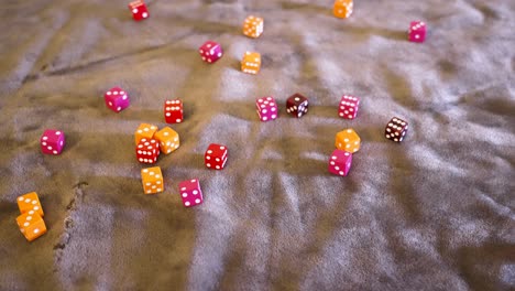 various dice, reds, oranges, and pinks on gray felt