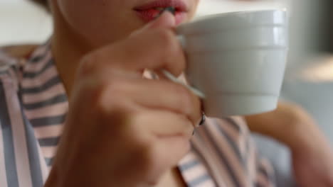 hand holding coffee cup closeup. relaxed girl enjoy morning beverage on couch