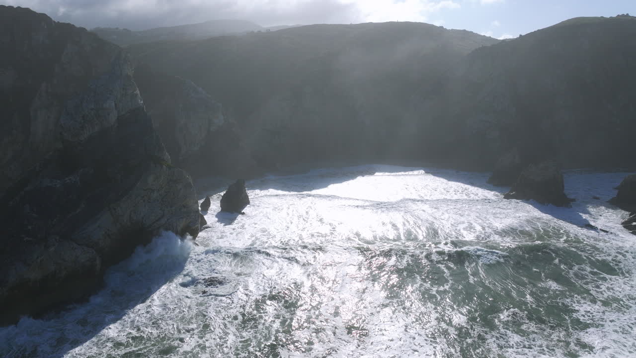 Vista aerea di una drammatica scena costiera con onde che si infrangono