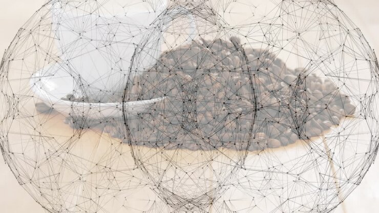 White ceramic coffee cup resting on saucer beside roasted beans, network overlay adding tech
