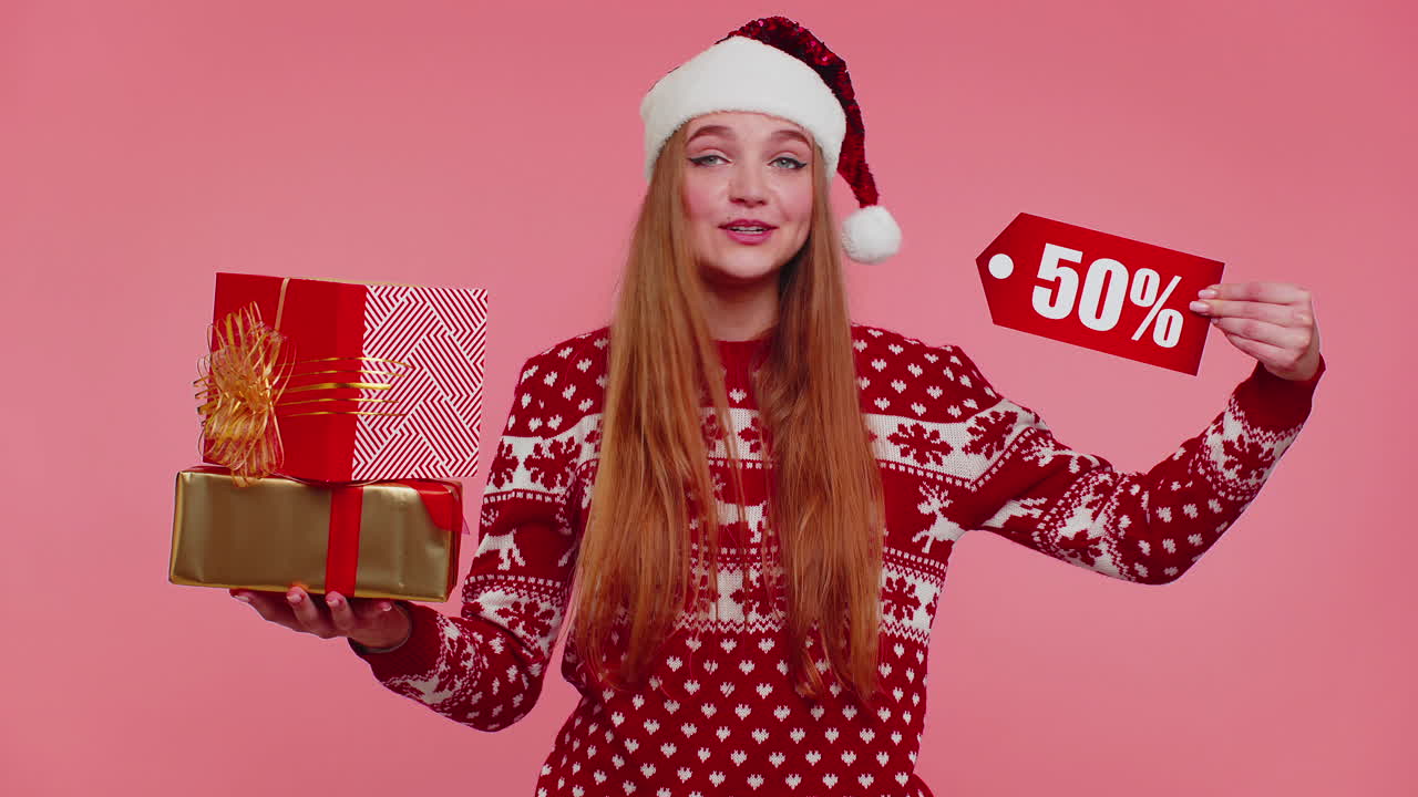 niña con suéter de navidad rojo mostrando caja de regalos y inscripciones de descuento del 50 por ciento nota de texto de banner