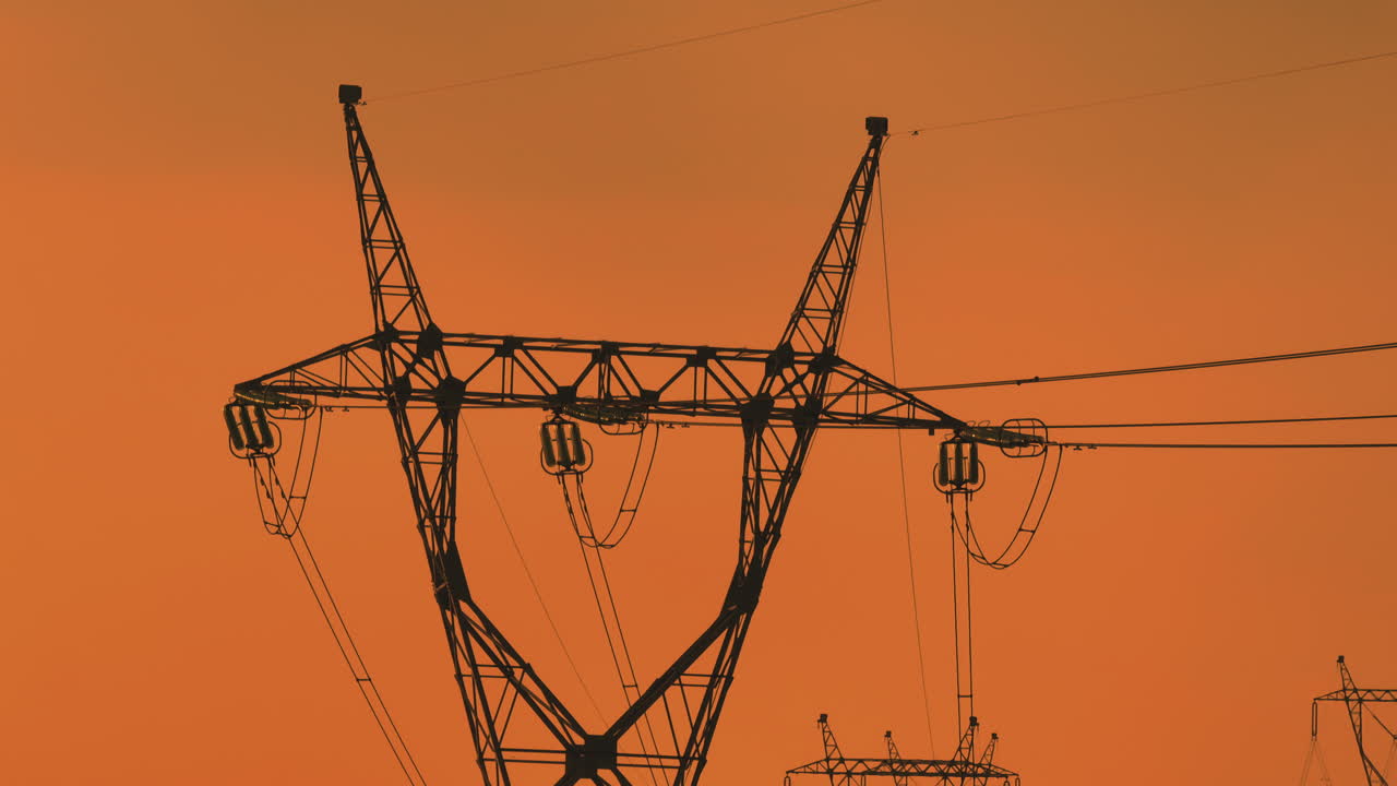 Silhouette of Power Transmission Towers at Sunset