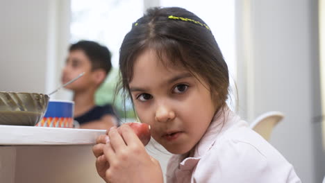 una vista de cerca de una niña pequeña tomando el desayuno.