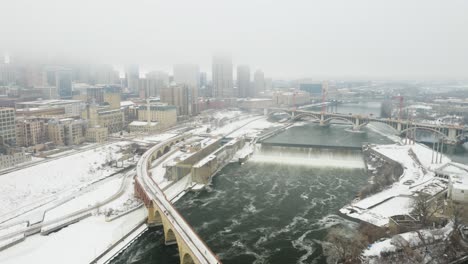 drone orbits over stone arch bridge and saint anthony falls