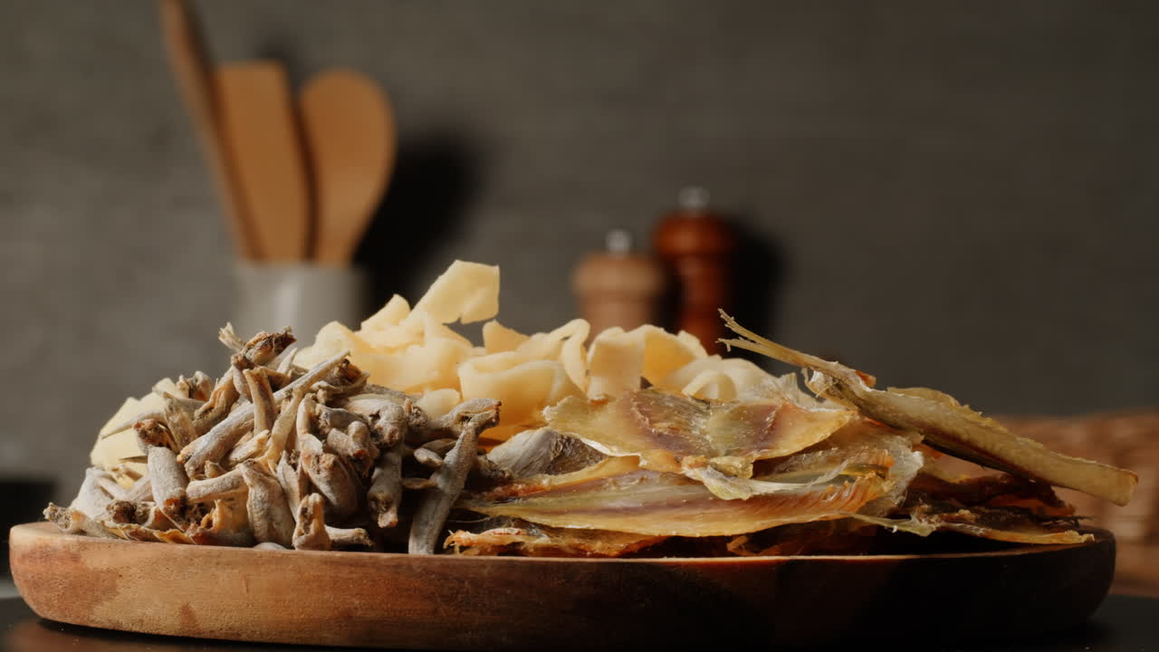 Assortment of Dried Fish Snacks on Wooden Plate