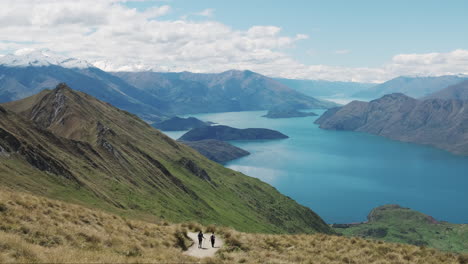 slow pan of tourists hiking roys peak track in new zealand