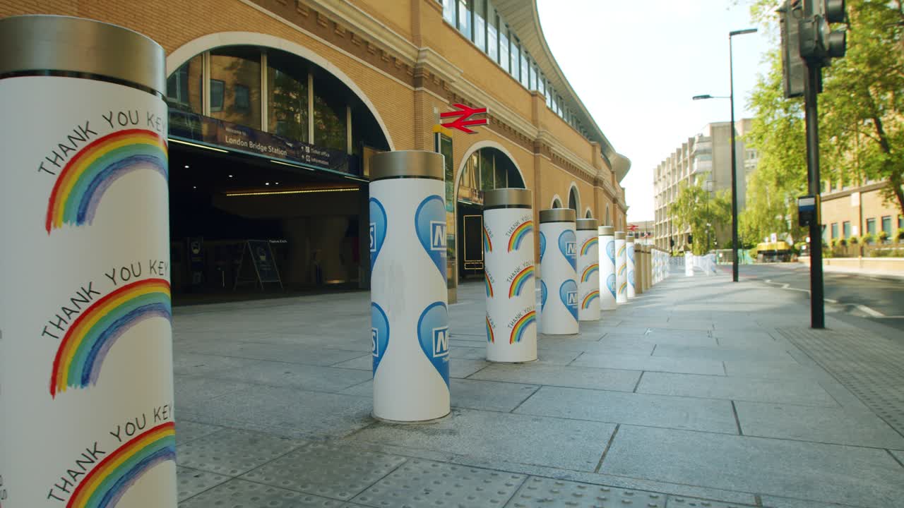 Bollards with Thank You NHS and Thank You Key Workers rainbow signage outside empty London Bridge station, during the COVID-19 lockdown pandemic 2020.