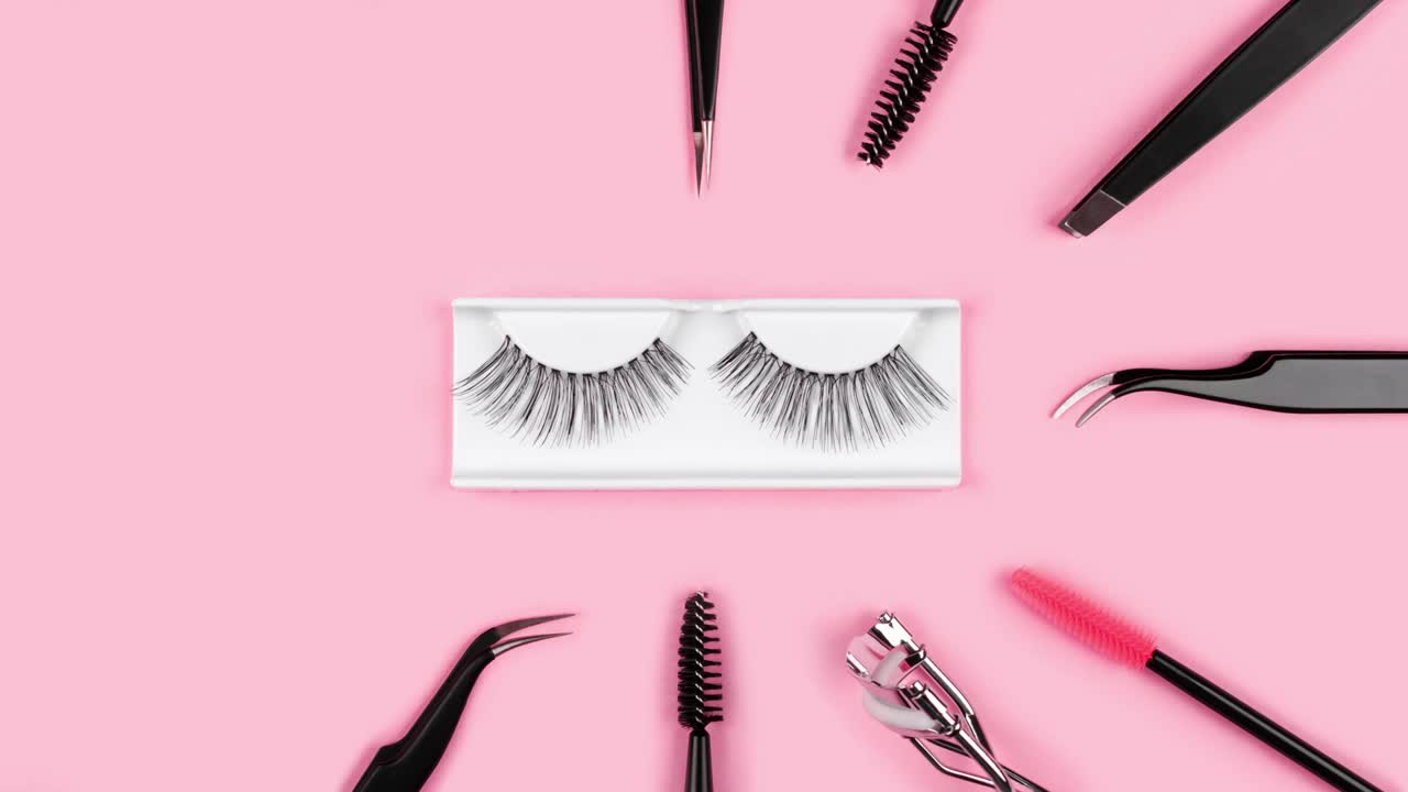 Sminketilbehør. Løsvipper. Verktøy for vippeextensions på trendy pastellrosa bakgrunn. Konsept. Vippetang, pinsett, koster, mascara. Kosmetiske produkter. Animasjon. Skjønnhetsmønster