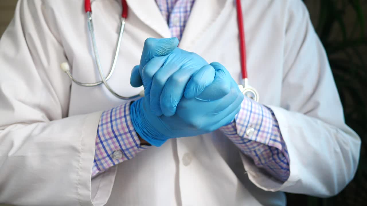 O médico vestindo luvas
