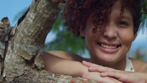 amazing facial close up of a young curly red hair girl smiling in a park on a sunny day