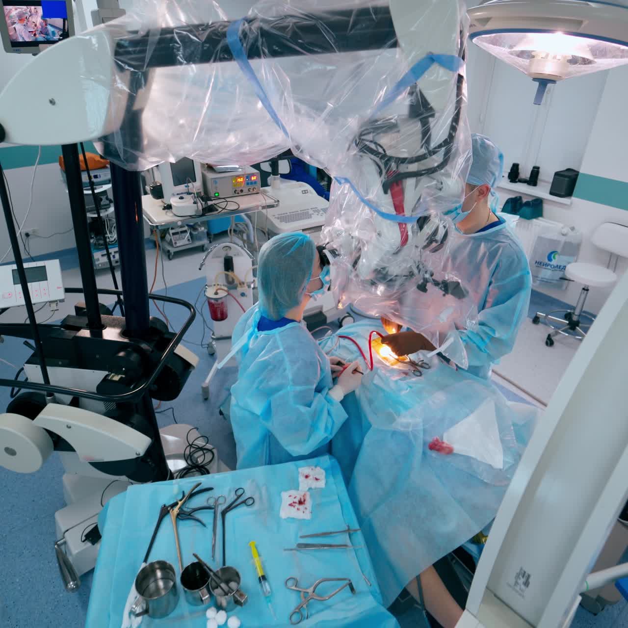 Surgeon in modern operating theater. Professional doctor and assistant in medical uniform conduct an operation on medical equipment background. Top view.