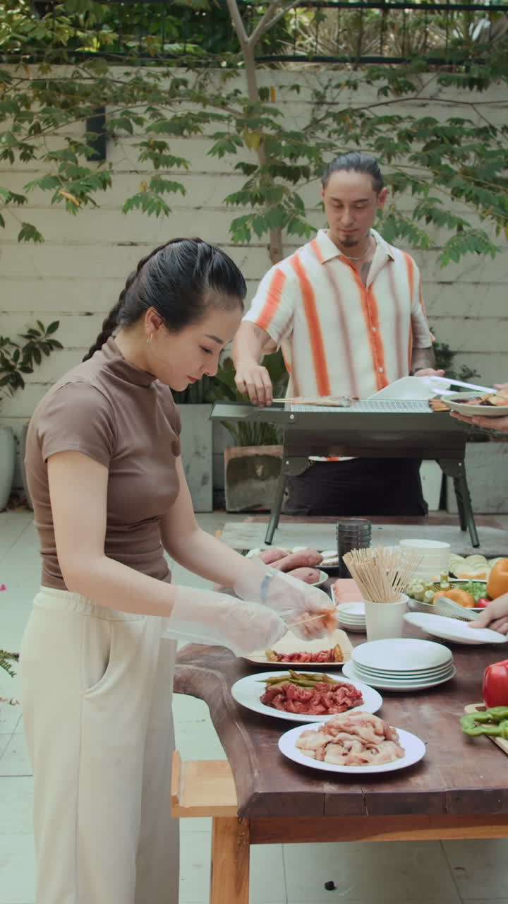 Vertical of Friends Cooking Barbecue at Outdoor Party