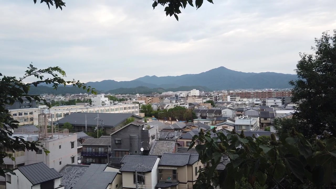 Veduta aerea della città di Kyoto, quartiere giapponese con case tradizionali e sfondo montuoso, area residenziale.