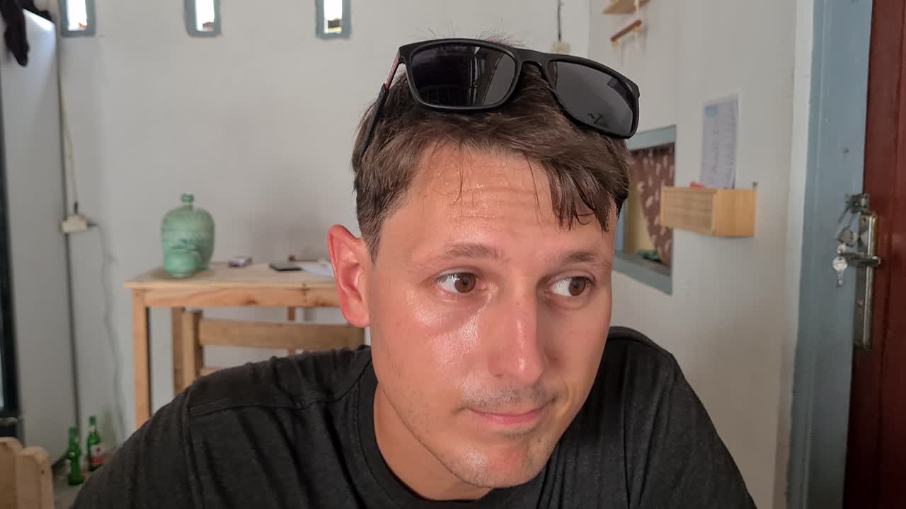 Man With Sweats On His Forehead With Sunglasses On His Head. - zoom in shot