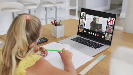 composite of girl using laptop for online lesson at home, with diverse teacher and class on screen