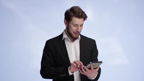 good looking man typing on his tablet and showing your product into the camera