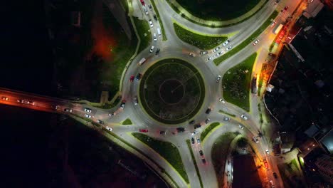 arriba hacia abajo de la antena de los automóviles que conducen en avenidas concurridas en la rotonda de concon iluminada por la noche, valparaíso, chile