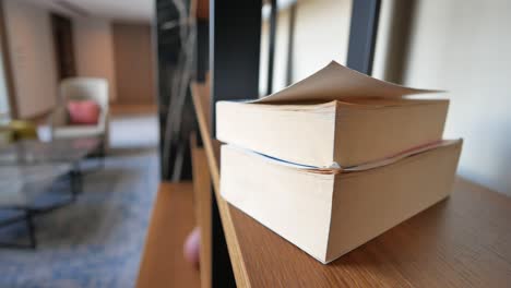 libros en un estante de madera en una sala de estar