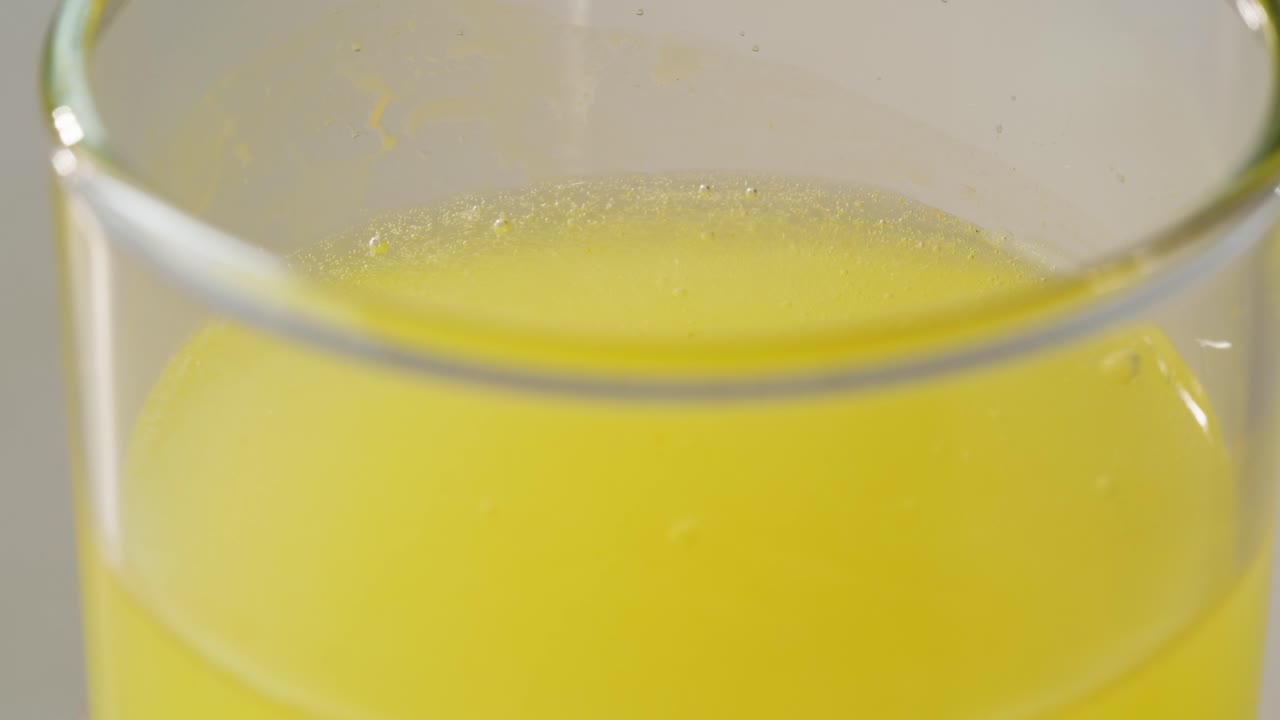 노란색 액체 한 잔의 클로즈업