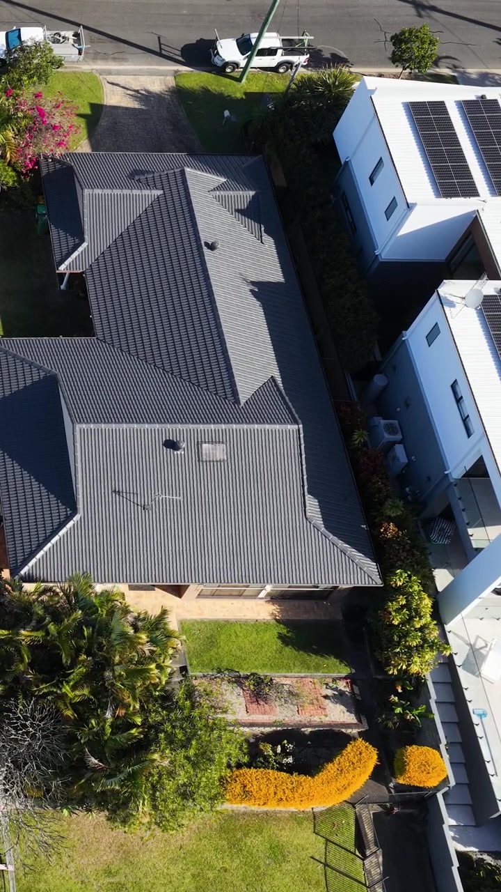 Aerial View of Residential House with Dark Metal Roof