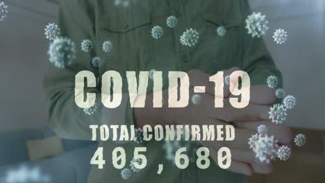 animación de la palabra covid-19 e información científica con el hombre desinfectando las manos en la oficina