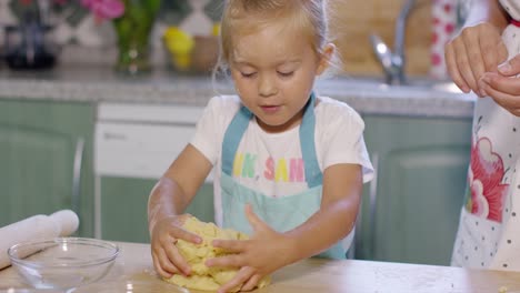 niña divirtiéndose amasando los pasteles
