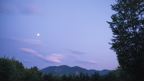 Moon-moving-over-ski-mountain-in-the-summer-with-beautiful-colorful-clouds