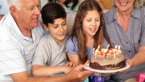 familia extendida feliz celebrando un cumpleaños y soplando velas