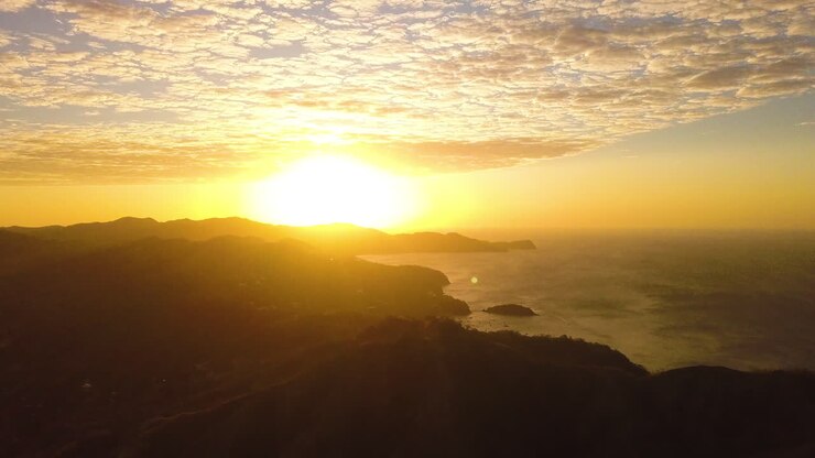 Vista aérea de un brillante amanecer amarillo sobre una montaña tropical