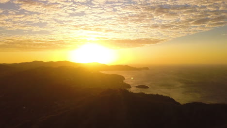 aerial view of a bright yellow sunrise over a tropical mountain