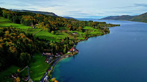 cinematic drone shot of village near attersee lake in the austrian alps, scenic european town in the hills, austria, europe