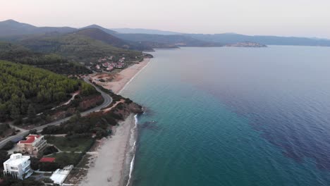 Drone-Aéreo-Sobre-La-Playa-De-La-Costa-Egea-Al-Atardecer-Aguas-Cristalinas-Bosque-De-Coníferas