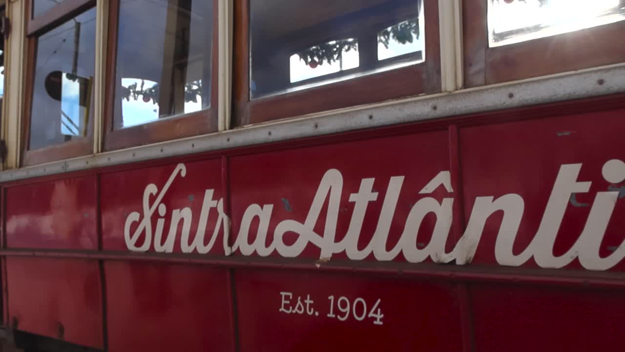 Close up view of vintage white lettering painted on a historic Sintra electric tram captured during a sunny day along the Portuguese coastline