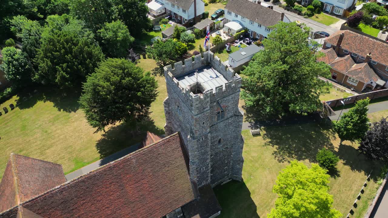 An angled arc-shot of St Mary's church in Chartham, focusing on the union flag flying from the church tower