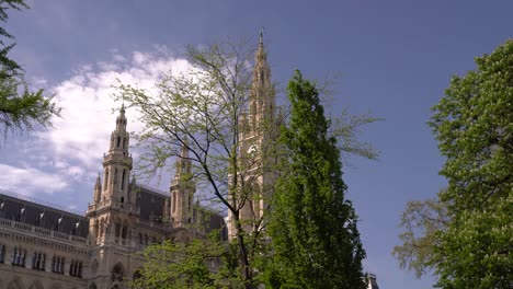 Famous-Vienna-City-Hall-locked-off-view-in-between-green-trees-and-blue-sky