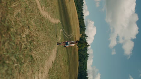 young girl photographer walking with camera young photographer walking with camera on grass hill girl watching at beautiful landscape and amazing nature view spending leisure time outdoor slow motion front view