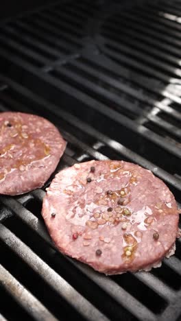 raw hamburgers cooking on a grill