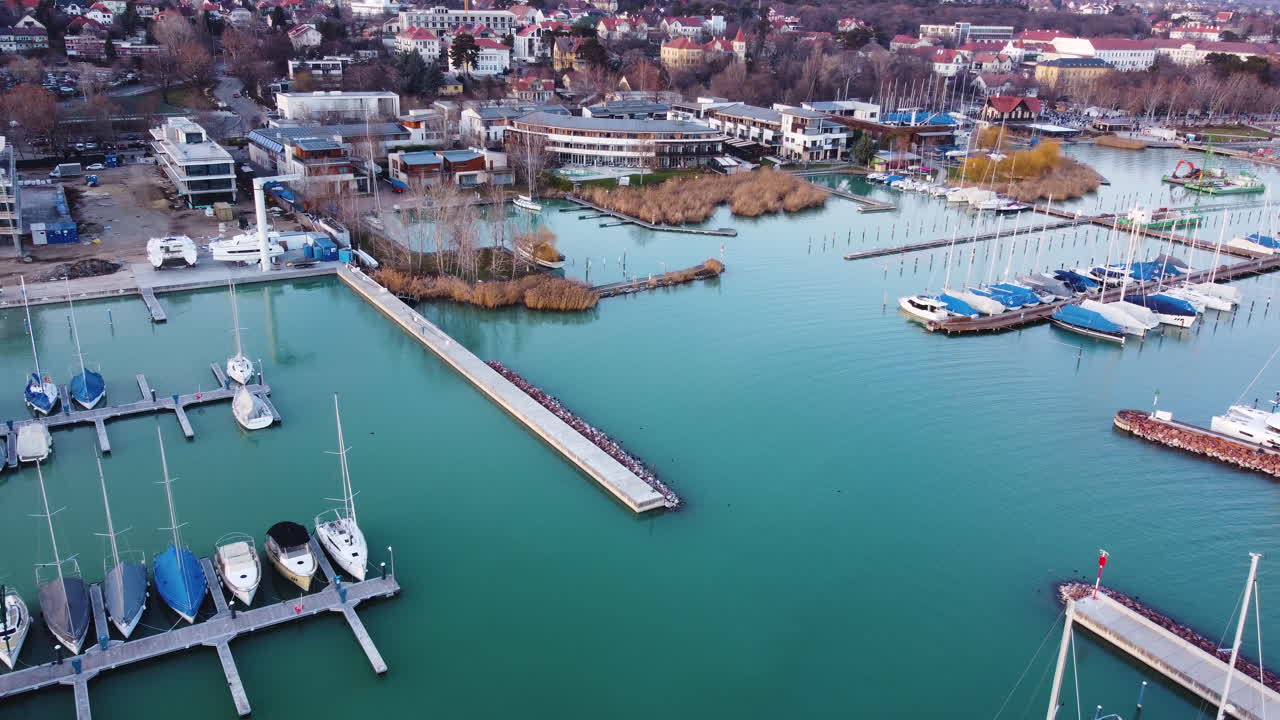 Drone shot of Balatonfured marina and waterfront at golden hour with piers and calm waters