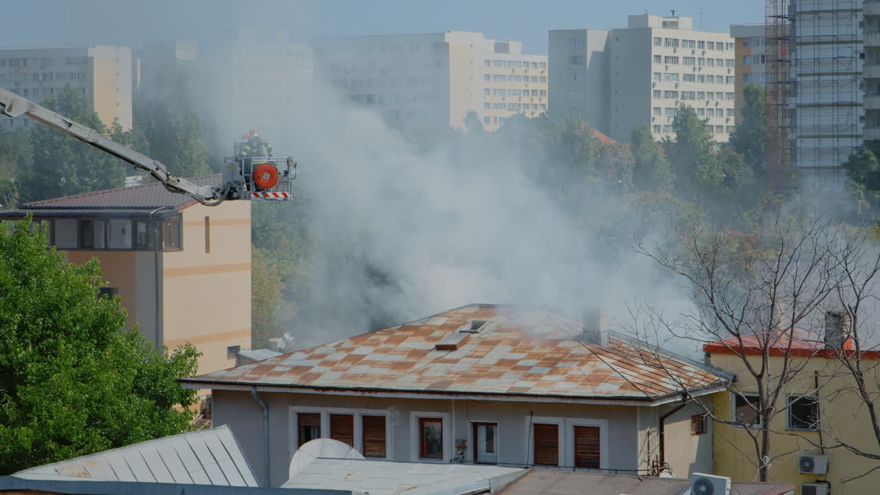 Close up of firefighters on platform truck helping with fire