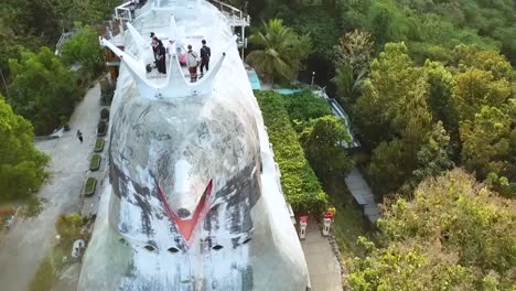 Tourists-enjoys-view-from-chicken-style-church-building-in-Indonesia,-aerial-view