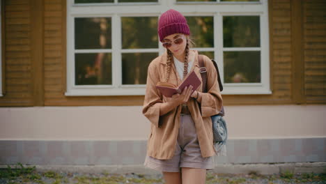 Female-Tourist-Reading-Book-In-Front-Of-Building