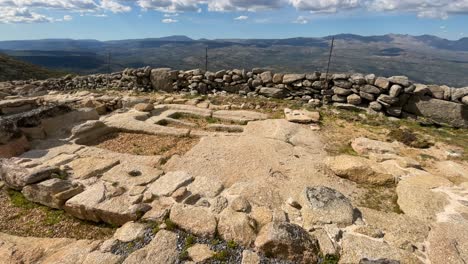 Vemos-Una-Zona-Arqueológica-Restaurada-Y-Limpiada-Con-Grava-Gris-Donde-Vemos-2-Tumbas-Antropomorfas-Del-Siglo-VII-época-Visigoda-Y-Unas-Hileras-De-Piedras-Formando-Muros-Vemos-Un-Valle