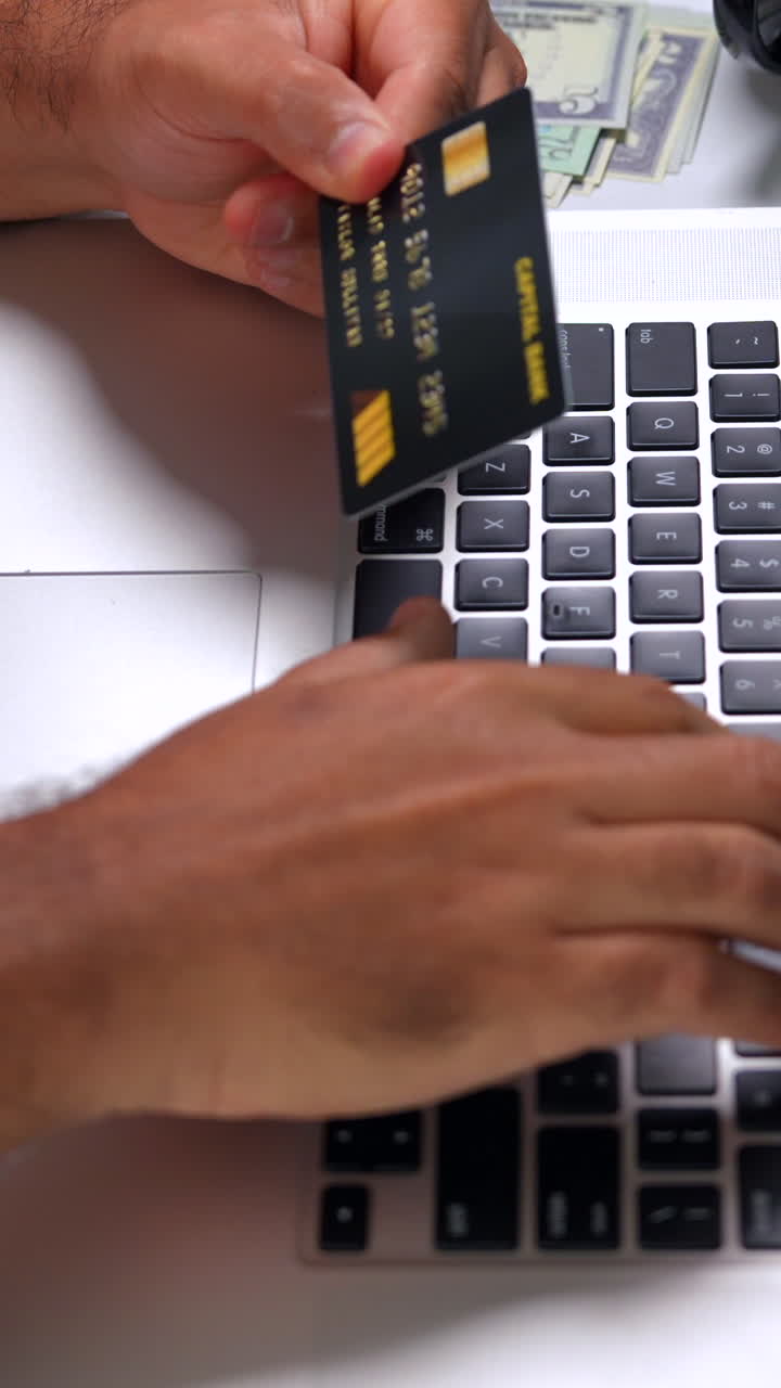 Engaging vertical video close-up of hands using a laptop for online shopping. The lighting is bright, emphasizing the dynamic action of entering credit card details for purchase