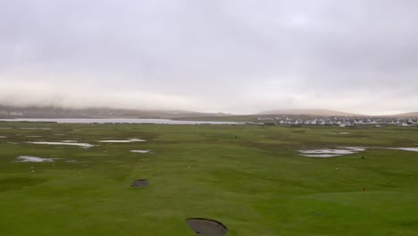 Aerial-view-over-the-muddy-coastal-landscape-of-Achill-Island,-off-the-coast-of-Western-Ireland,-on-a-wet-afternoon