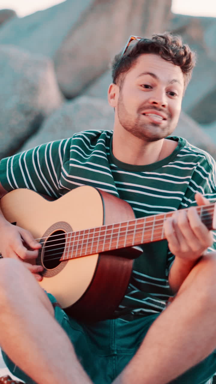 Giovane uomo felice che suona la chitarra acustica e canta all'aperto